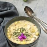 eine Schale Chowder garniert mit Dille und einer Blüte
