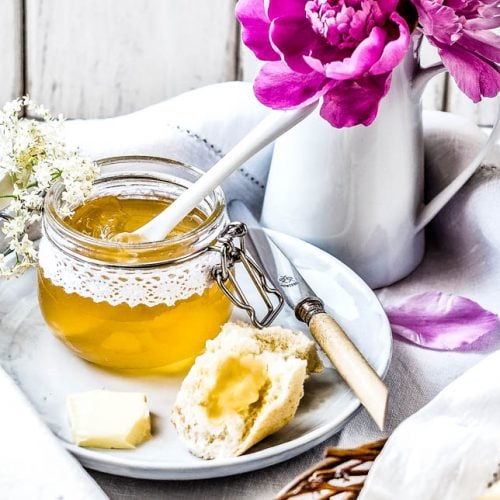 Ein Frühstückstablett mit Holunderblütengelee, Gebäck und Blumen