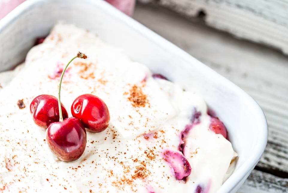 Eine Schüssel mit Tiramisu und Kirschen.