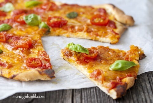 sliced ​​Margherita pizza lies on baking paper