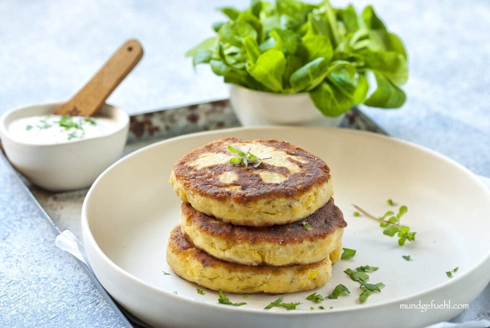 Topfenlaibchen mit Kartoffeln auf einem Teller angerichtet und mit einem Dip und Salat garniert.