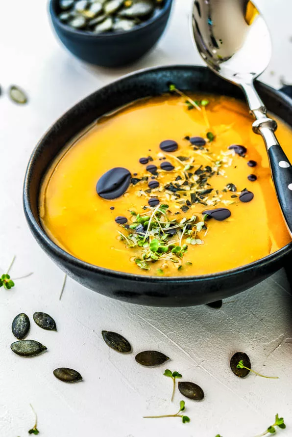 Angerichtete Kürbissuppe mit Kürbiskernöl und Kürbiskernen