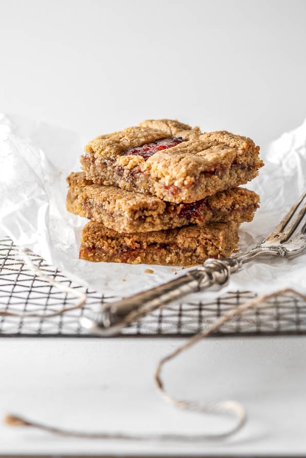Drei Stück Linzer Schnitten liegen aufeinander auf einem Gitter