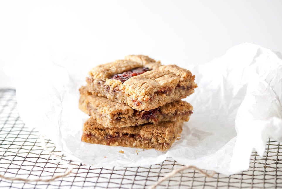 Drei Stück Linzer Schnitten liegen aufeinander auf einem Gitter