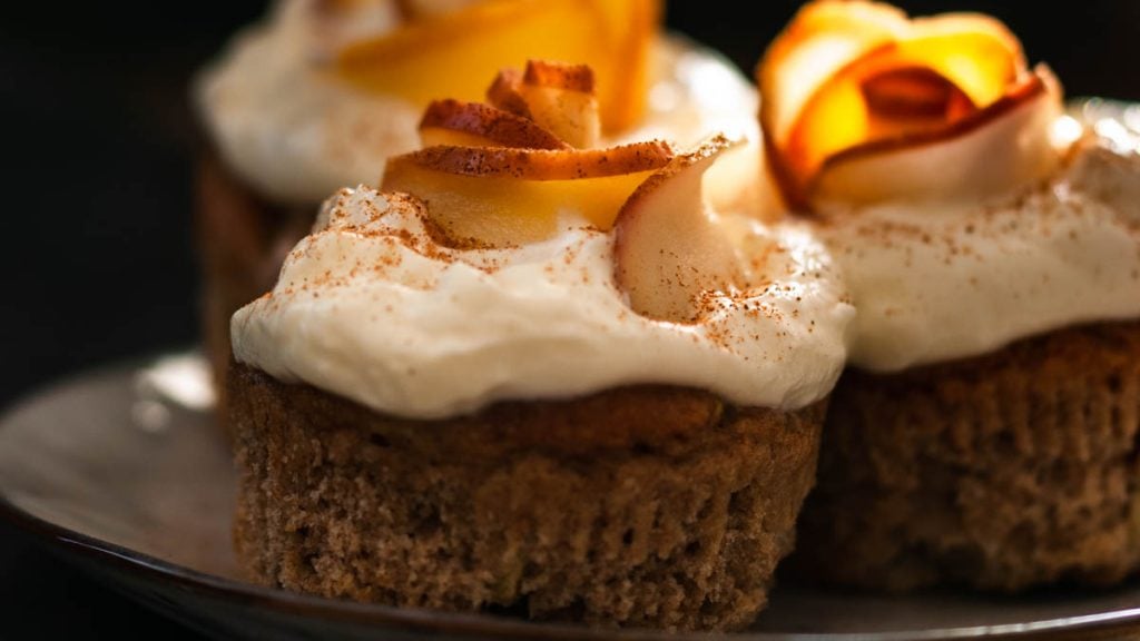 Apfel-Dinkelmuffins auf einem Teller auf einer Holzplatte