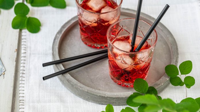 campari-spritz-mit-prosecco Zwei Campari Gläser mit Strohhalmen auf Tablett