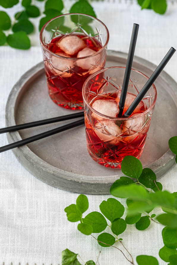 Zwei Campari Gläser mit Strohhalmen auf Tablett