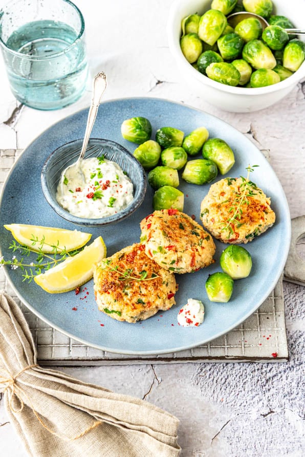Fischbuletten mit Gemüse und Sauce Tartar auf Teller