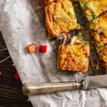 in Stücke geschnittene Frittata liegt auf Backpapier und daneben ein Messer