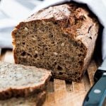 Brot liegt mit einem Messer auf einem Holzbrett