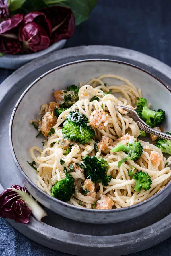 Spaghetti mit Kürbis und Brokkoli am Tisch