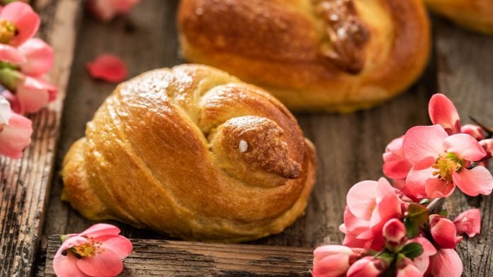 Brioche Küken liegen auf Holzuntergrund mit Blumendeko