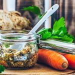 Karotten, Sellerie und Petersilie für Gemüsebrühe im Glas liegen auf einem Brett