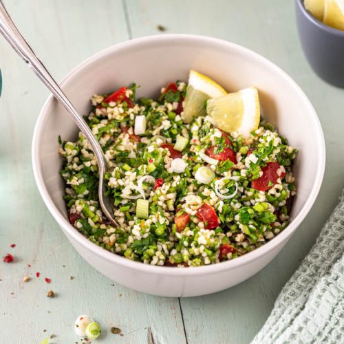 Zwei Schüsseln mit Petersiliensalat und Gläsern auf Tisch