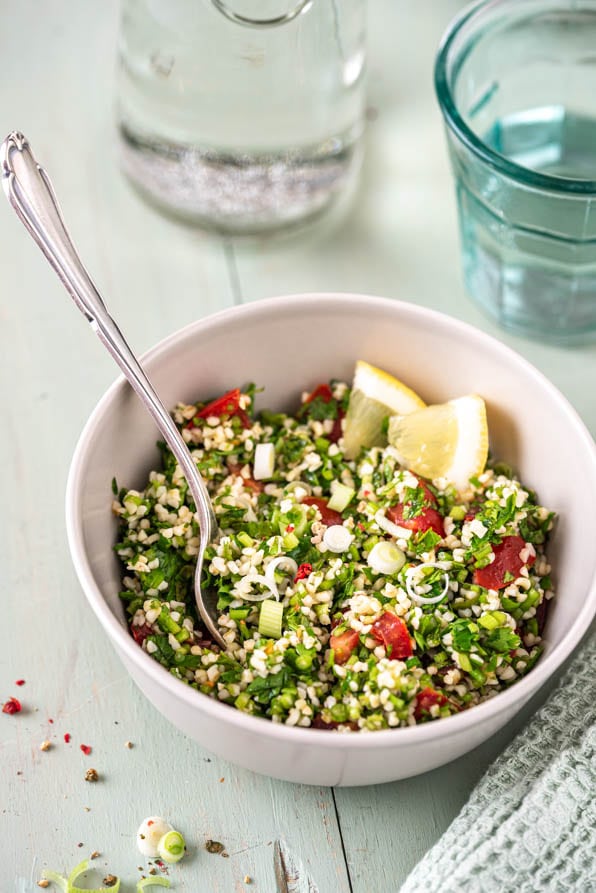 Zwei Schüsseln mit Tabouleh und Gläsern auf Tisch