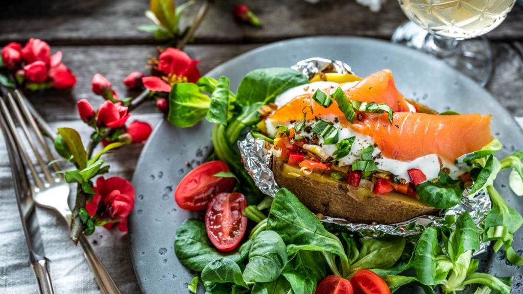 Ofenkartoffel mit Lachs wurde auf Salatbett angerichtet