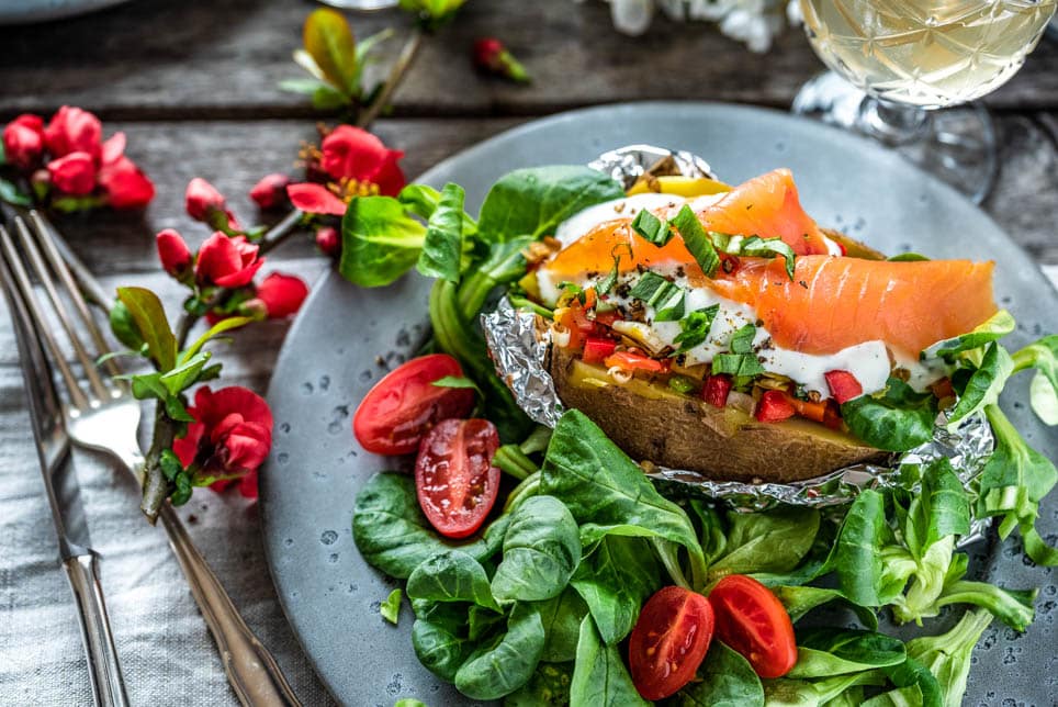 Ofenkartoffel mit Lachs wurde auf Salatbett angerichtet