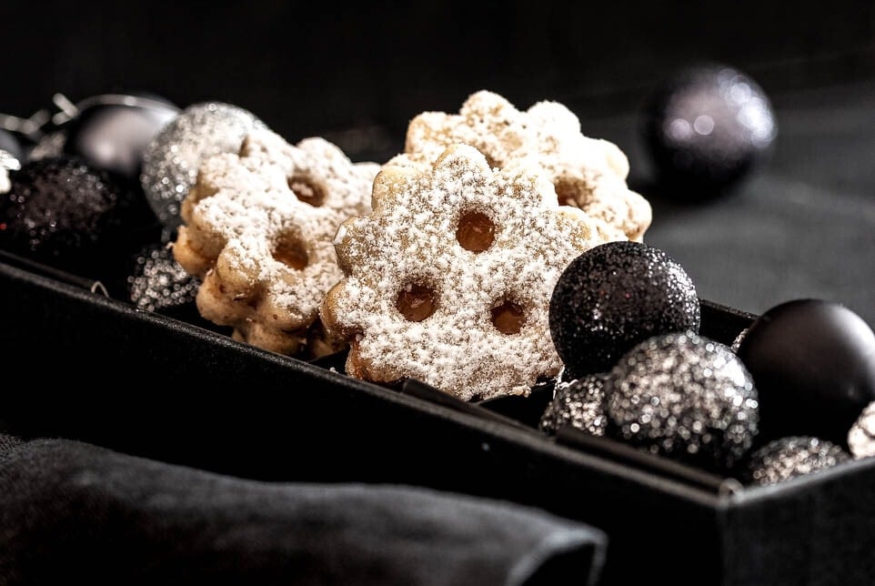 Linzer Augen liegen in einer Schachtel mit Weihnachtskugeln