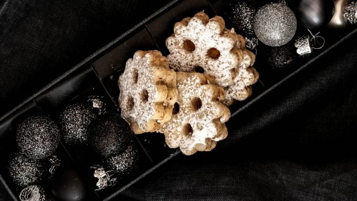 Linzer Augen liegen in einer Schachtel mit Weihnachtskugeln