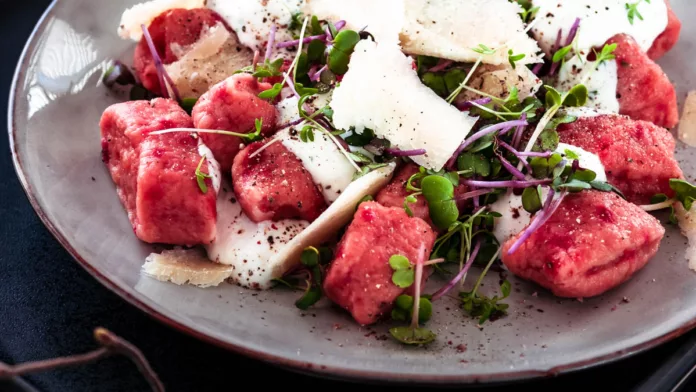 rote Bete Gnocchi auf einem Teller mit Parmesan