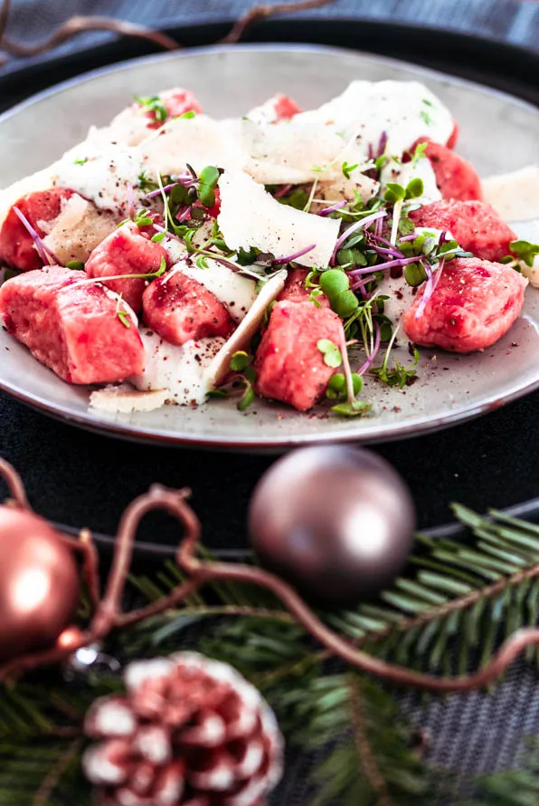 rote Bete Gnocchi auf Teller mit weihnachtlicher Dekoration