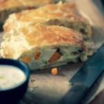 aufgeschnittener Gemüsetrudel auf Brett mit Sauce