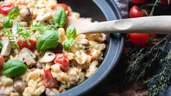 Spätzle mit Tomaten und Basilikum in einer grauen Pfanne