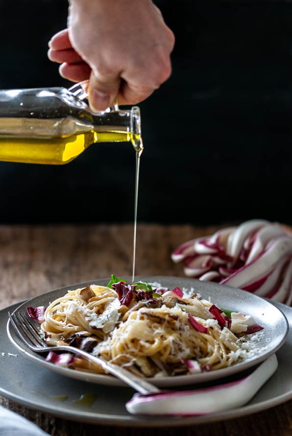 Ein Teller mit Spaghetti und gebratenem Radicchio steht am Tisch