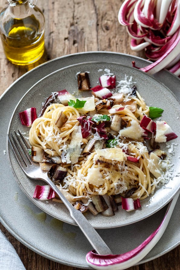 Ein Teller mit Spaghetti und gebratenem Radicchio steht am Tisch