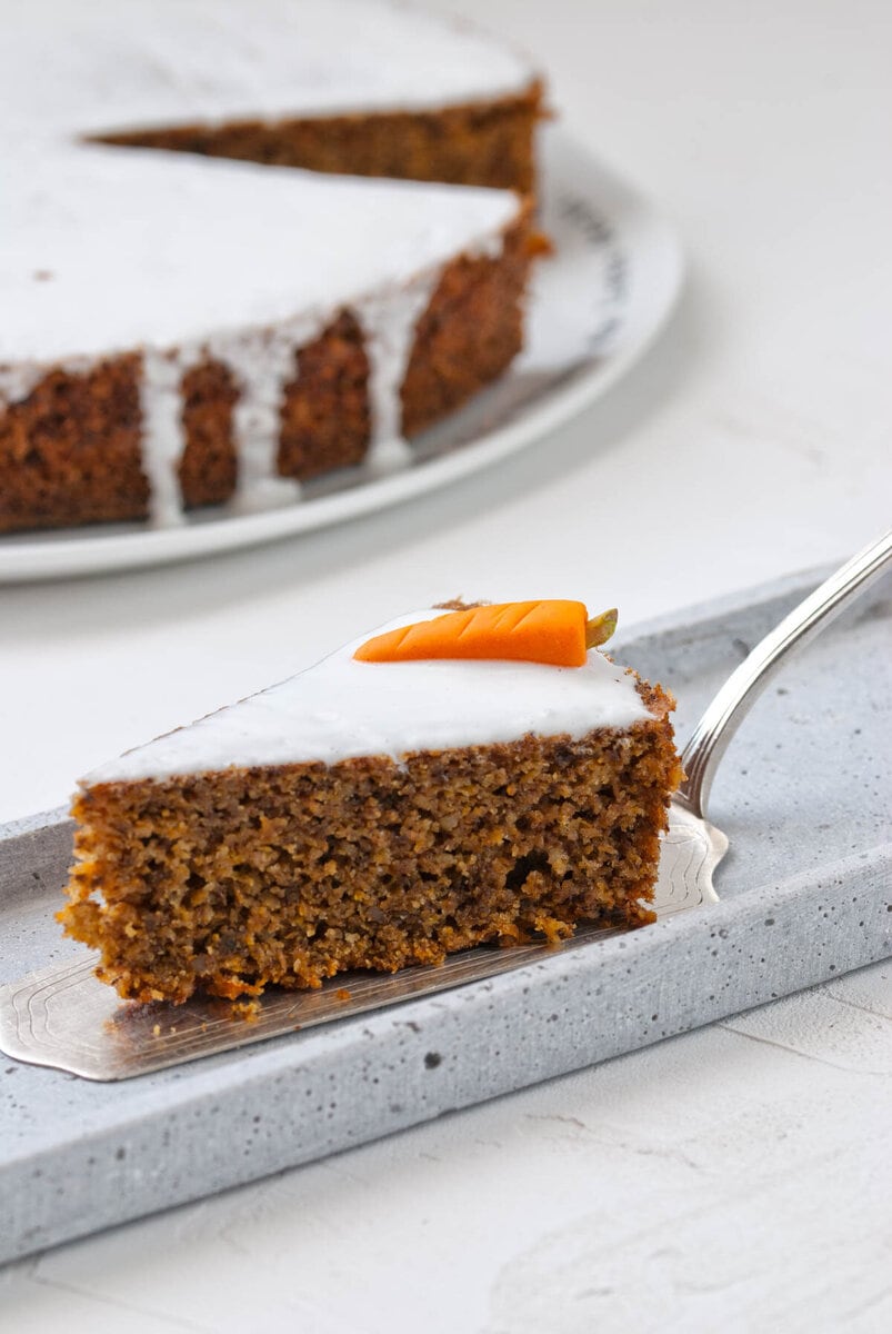 Stück Torte liegt auf Tortenschaufel und Teller vor Torte