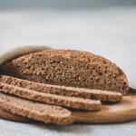 Laib Brot mit aufgeschnittenen Scheiben auf Brett