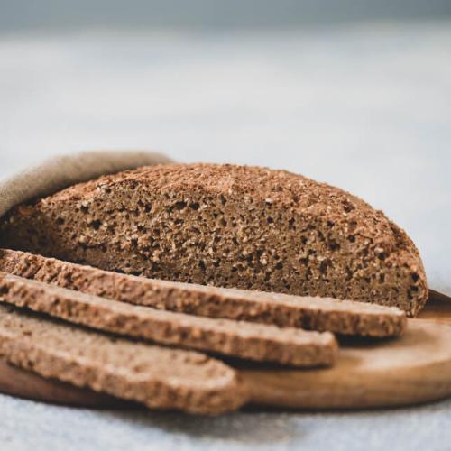 Laib Brot mit aufgeschnittenen Scheiben auf Brett