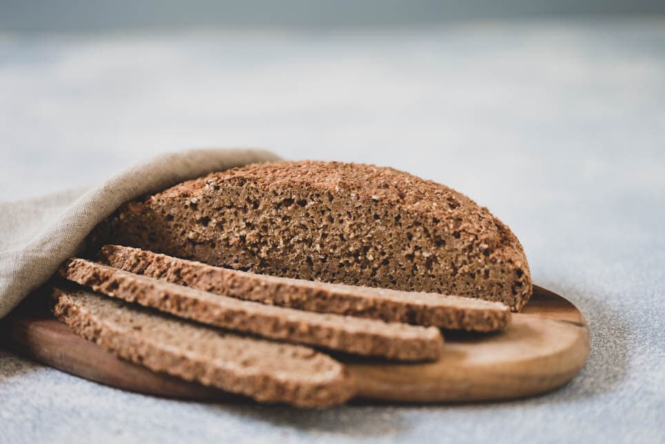 Laib Brot mit aufgeschnittenen Scheiben auf Brett