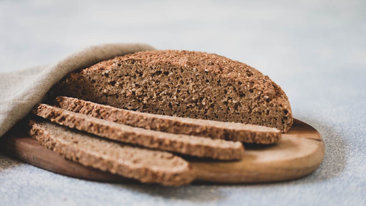 Laib Brot mit aufgeschnittenen Scheiben auf Brett