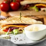 Club Sandwich ist mit Aioli auf einem Teller angerichtet