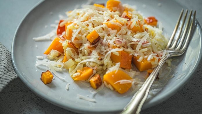 Risotto mit Kürbis und Speck auf einem Teller