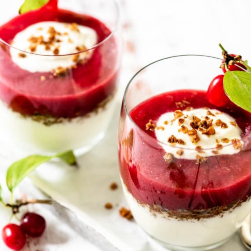 Zwei Dessertgläser mit Fruchtcreme stehen auf Tablett