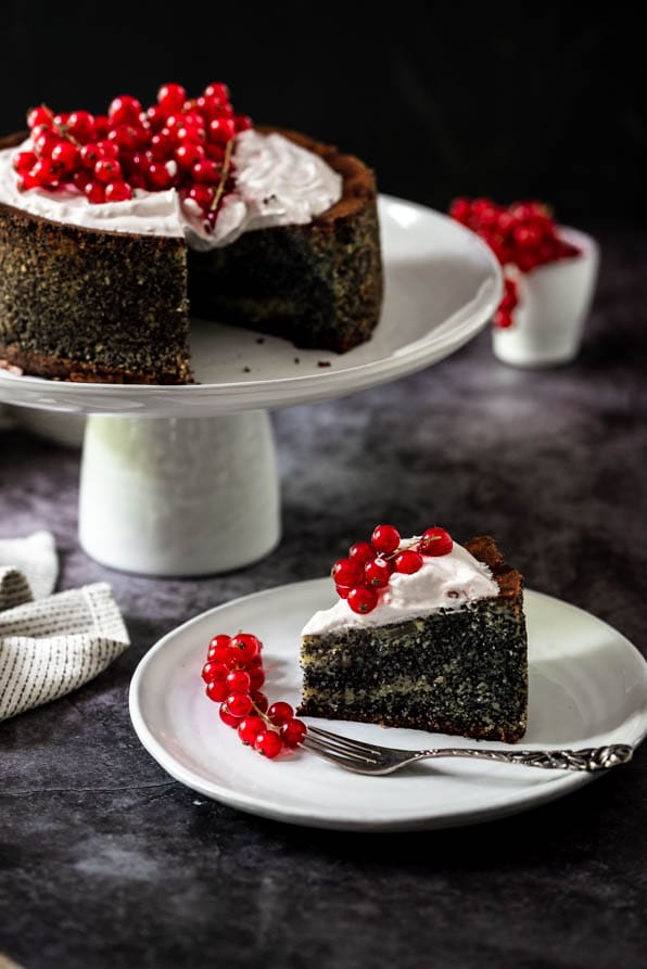Mohntorte garniert mit Ribiseln steht auf Tortenständer