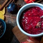 Eine Schale Pflaumenmarmelade steht neben einer Schale Pflaumen