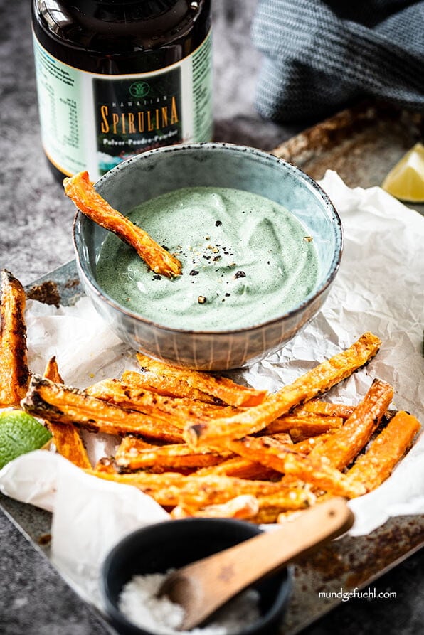 Süßkartoffelpommes mit Dip aus Avocado und Spirulina auf Tablett