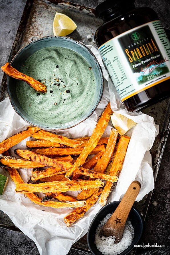 Süßkartoffelpommes mit Dip aus Avocado und Spirulina auf Tablett