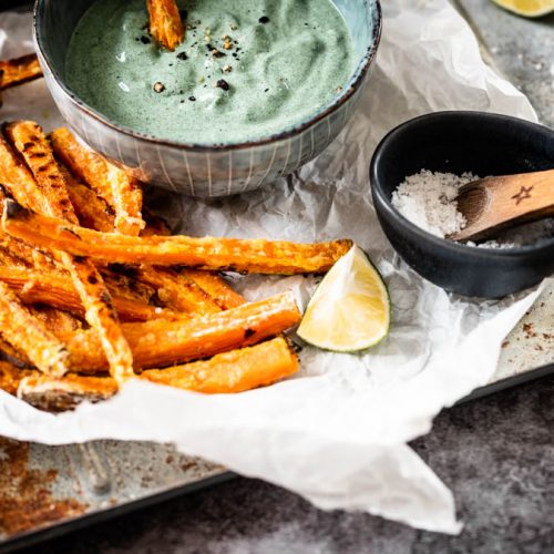 Süßkartoffelpommes mit Dip aus Avocado und Spirulina auf Tablett