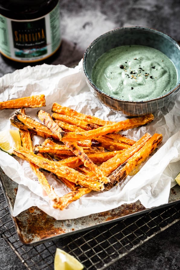 Süßkartoffelpommes mit Dip aus Avocado und Spirulina auf Tablett