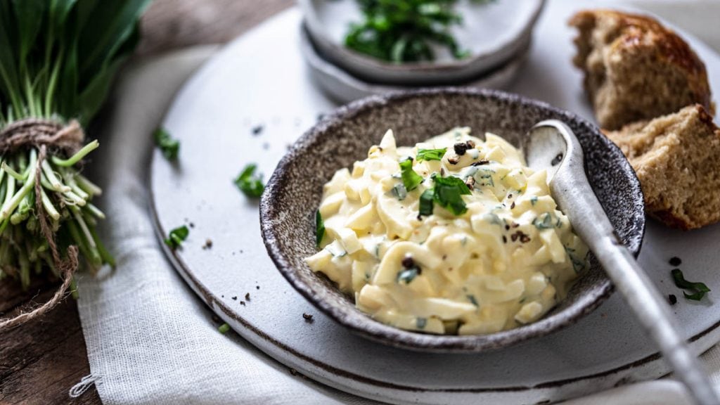 Eiersalat mit Bärlauch ist in einem Schälchen angerichtet