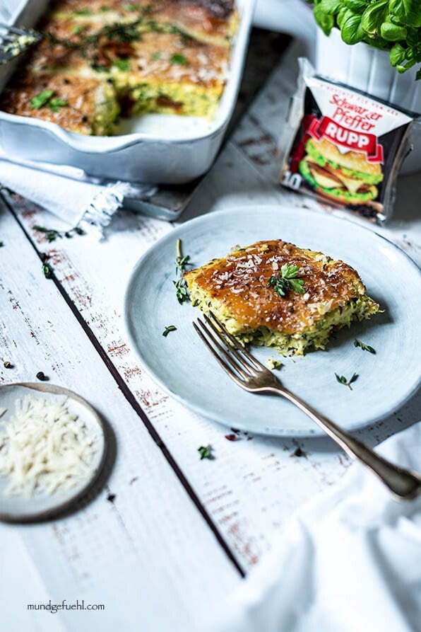 Ein Stück Zucchini Auflauf mit Ricotta liegt auf einem Teller
