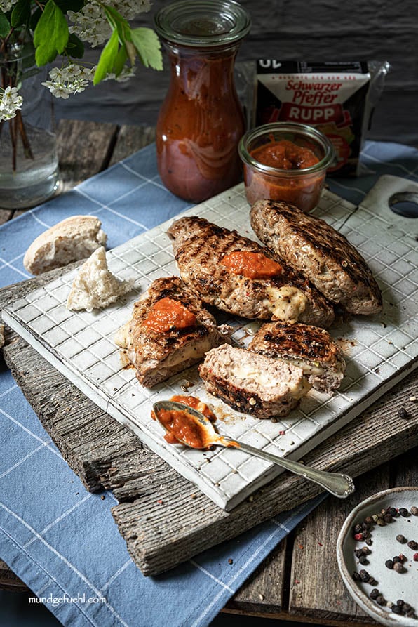 Pljeskavica liegt aufgeschnitten auf Brett