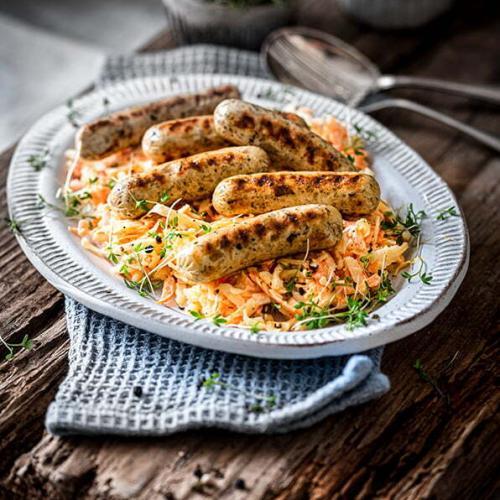 Rostbratwürstchen auf Coleslaw auf einem Teller