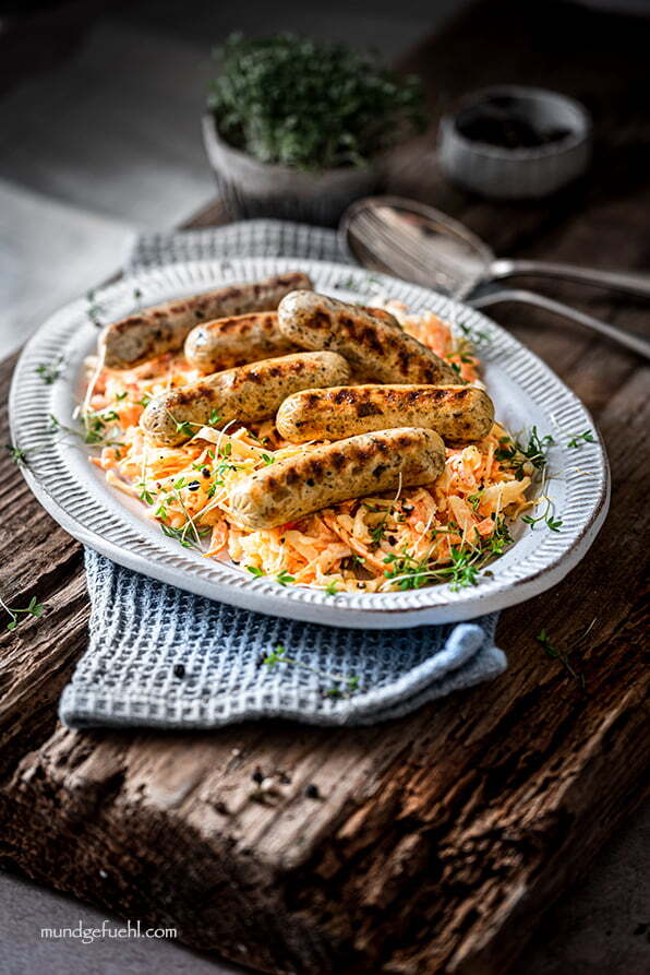 Rostbratwürstchen auf Coleslaw auf einem Teller