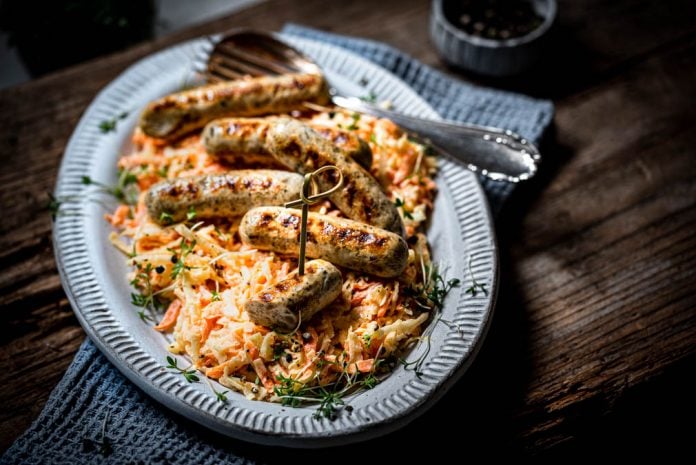 Rostbratwürstchen auf Coleslaw auf einem Teller