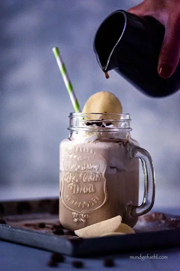 Wiener Eiskaffee im Glas - Hand gießt Kaffee ein
